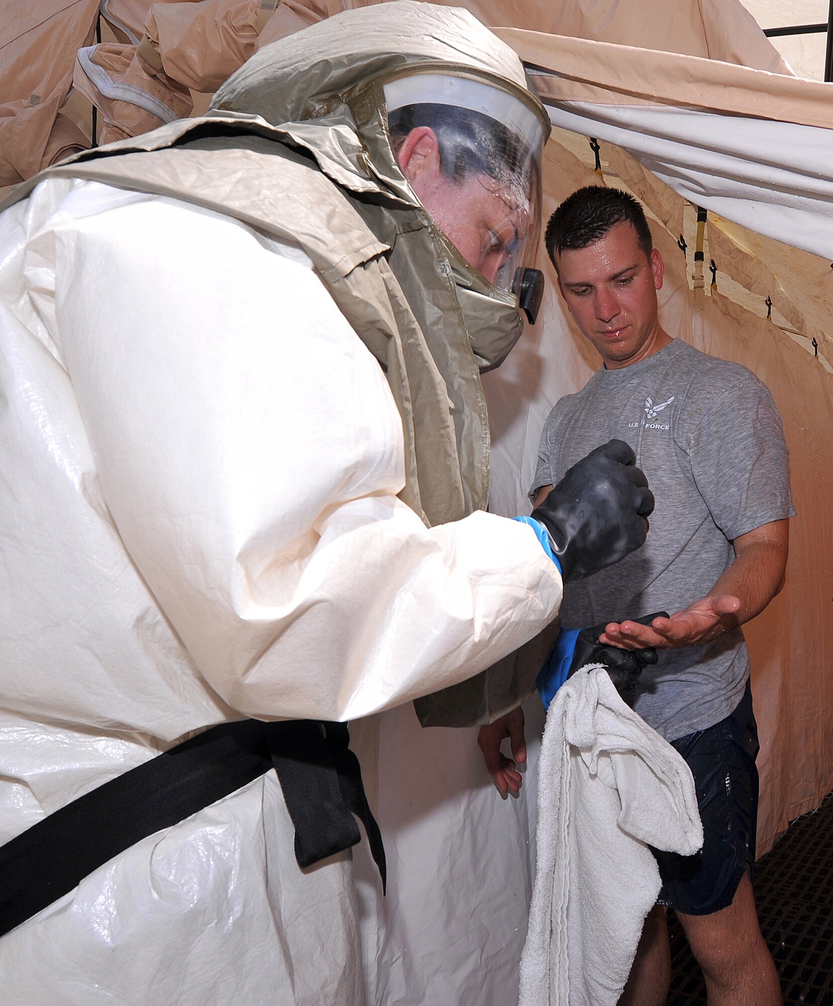 An Airman simulating being exposed to hazardous substances goes through the decontamination process during the In-Place Patient Decontamination Exercise. The exercise teaches IPPD team members to quickly set up a shelter to decontaminate patients who could be exposed to chemical spills or other harmful substances. (U. S. Air Force photo by Tommie Horton)