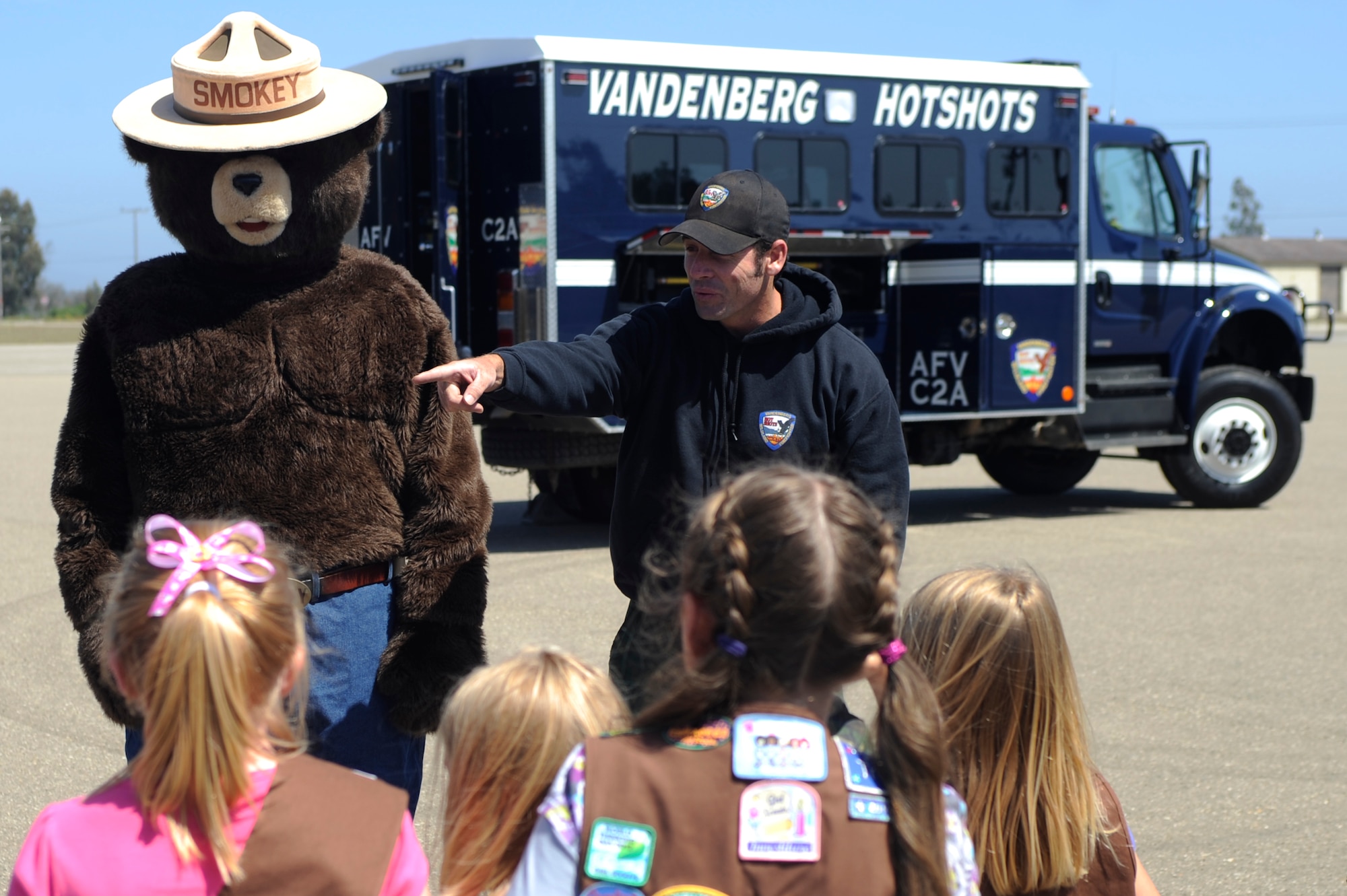 VANDENBERG AIR FORCE BASE, Calif. -- Nathan Ogan, a 30th Civil Engineer Squadron firefighter, asks a Space and Sea Girl Scout a question about fire safety at the parade grounds here Wednesday, May 9, 2012. The Vandenberg Hot Shots explained their role in fighting wilderness fires and showed the tools they use to fight fire. (U.S. Air Force photo/Staff Sgt. Andrew Satran) 

 