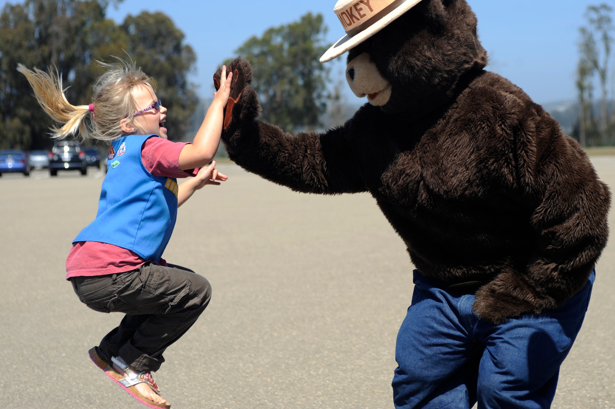 VANDENBERG AIR FORCE BASE, Calif. -- Katelyn Lowder, a Space and Sea Girl Scout, high fives Smokey the Bear during a Vandenberg Hot Shot fire safety awareness class at the parade grounds here Wednesday, May 9, 2012. The Vandenberg Hot Shots explained their role in fighting wilderness fires and showed the tools they use to fight fire. (U.S. Air Force photo/Staff Sgt. Andrew Satran) 

 