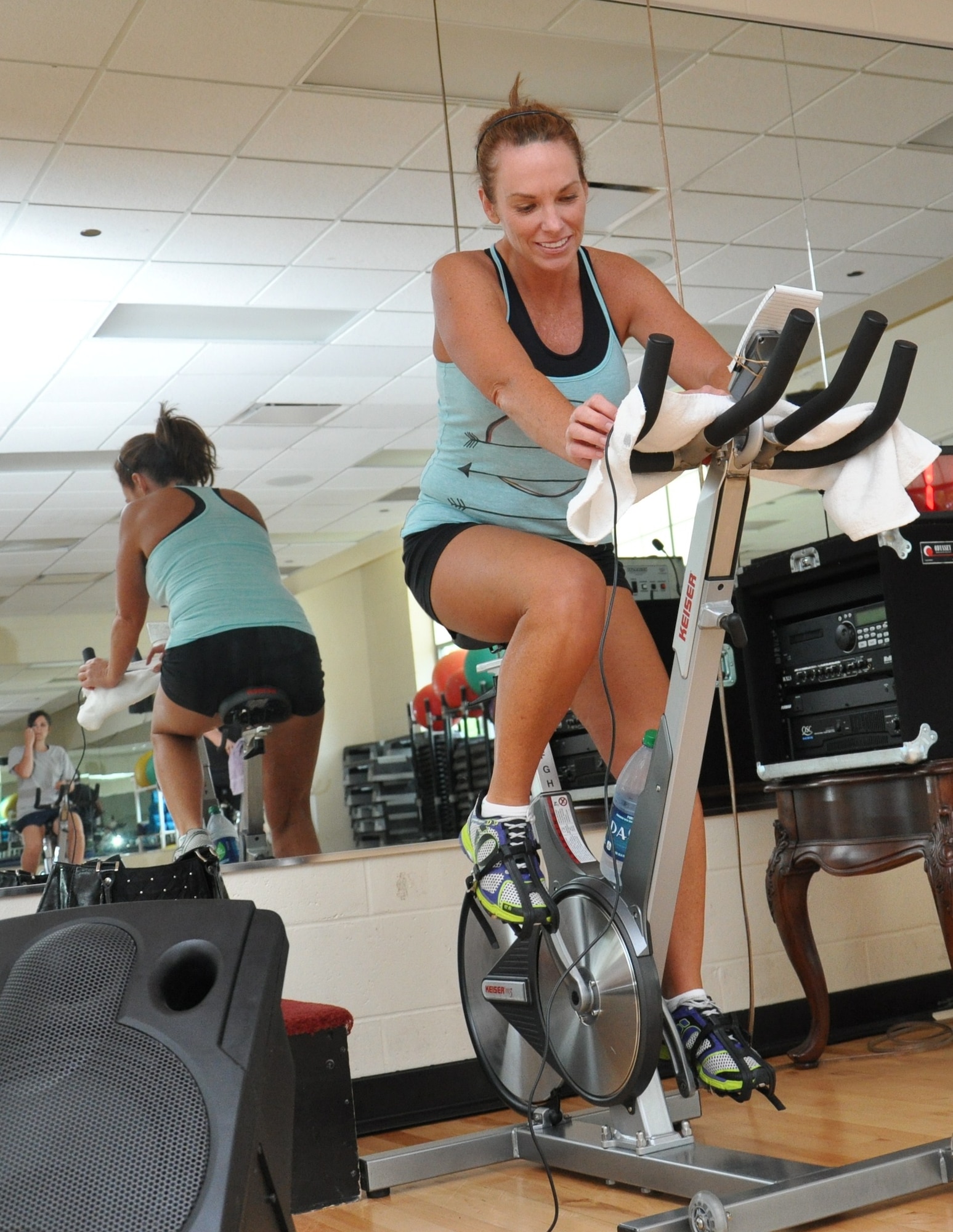 Michele Williamson, Air Force Global Strike Command chief scientist executive support, hops on her bike to teach a spin class at the Barksdale Fitness Center May 2. Williamson, whose husband is currently deployed, finds support from the military spouses on base. (U.S. Air Force photo by Kate Blais)