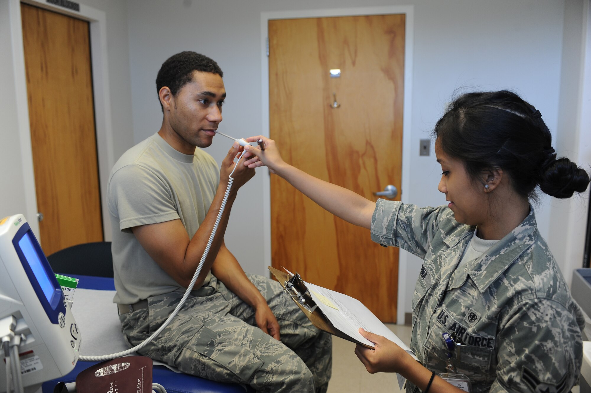 U.S. Air Force Airman 1st Class Janna Harina checks Senior Airman Reginald Graves’ temperature with a thermometer probe at the 4th Medical Group on Seymour Johnson Air Force Base, N.C., May 8, 2012. Along with taking patients’ temperatures Harina also checks their weight and records their blood pressure. Harina, 4th Medical Operations Squadron medical technician, is from San Diego. Graves, 4th Component Maintenance Squadron test measurement diagnostic equipment technician, is a native of Raleigh, N.C. (U.S. Air Force photo/Airman 1st Class John Nieves Camacho/Released)