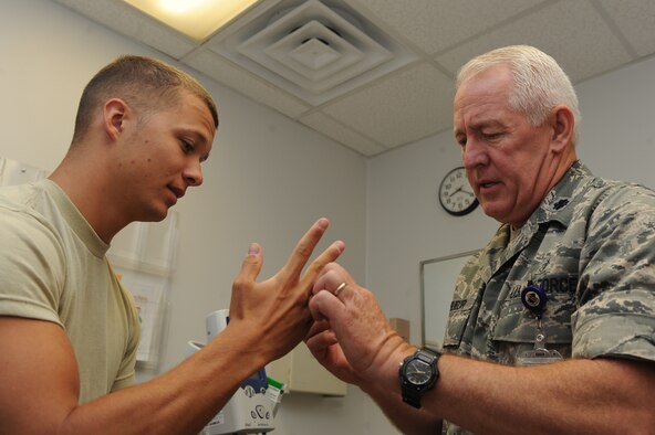 U.S. Air Force Lt. Col. Bret Lesueur examines Senior Airman Christopher Cavin’s hand during sick call at the 4th Medical Group on Seymour Johnson Air Force Base, N.C., May 9, 2012. Sick call, only open to active duty, enables the member to be triaged for illnesses that may prevent them from going to work. Lesueur, 4th Medical Operations Squadron flight commander, is from Orange County, Calif. Cavins, 4th Contracting Squadron contract specialist, hails from South Rockwood, Mich. (U.S. Air Force photo/Airman 1st Class John Nieves Camacho/Released)