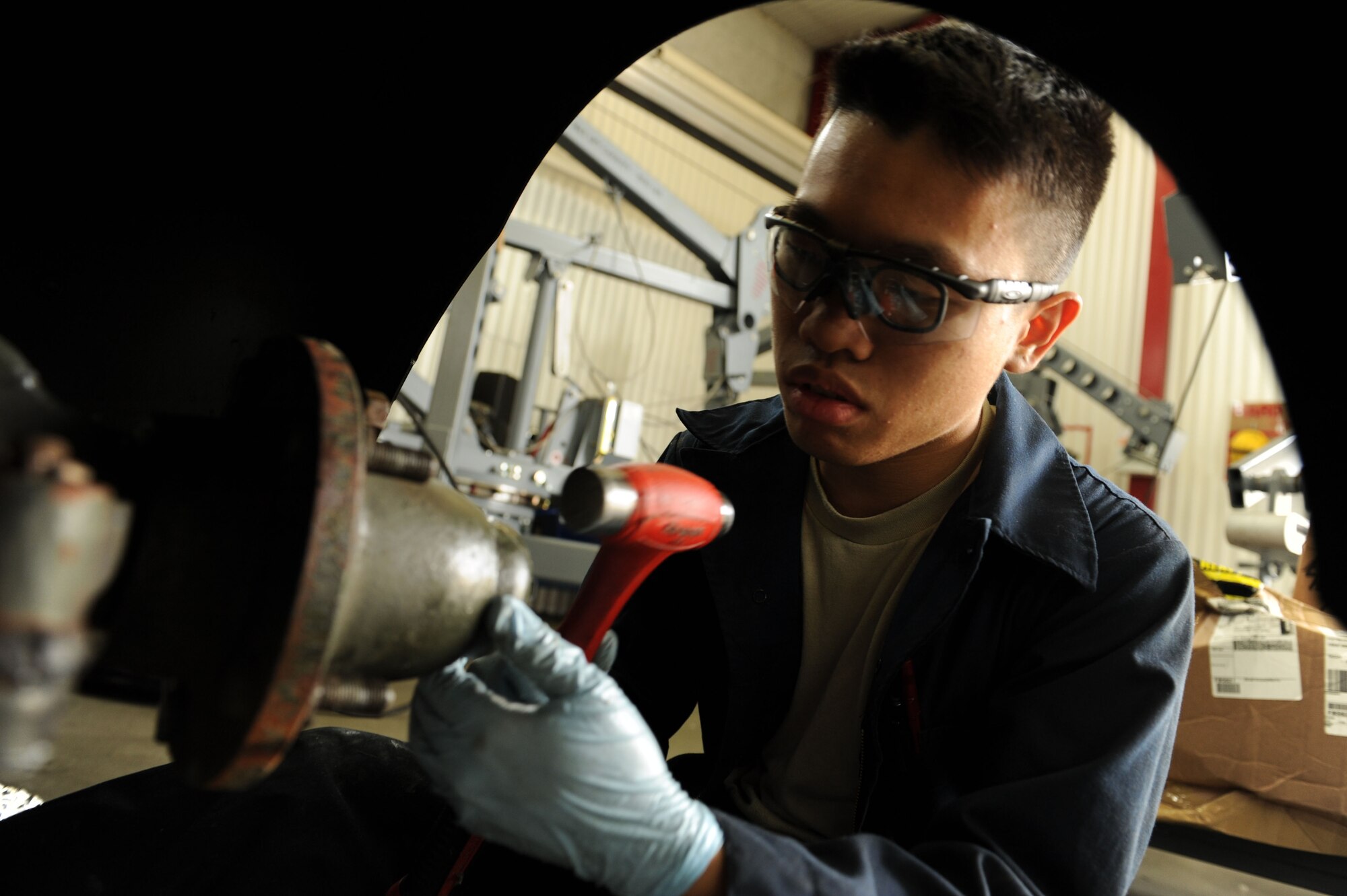 SPANGDAHLEM AIR BASE, Germany – Airman 1st Class Ernest Chim, 52nd Equipment Maintenance Squadron aerospace ground equipment apprentice, uses a ball penn hammer to attach a dust cap on a diesel generator to prevent condensation from forming during a wheel bearing inspection at the AGE inspection and repair shop in Bldg. 185 here. The AGE flight inspects these generators every two years to ensure they operate properly, and condensation is prevented to avoid corrosion and damage to the generator. AGE members also inspect, test and operate ground support equipment to support Spangdahlem AB’s aircraft operations. (U.S. Air Force photo by Senior Airman Christopher Toon/Released)