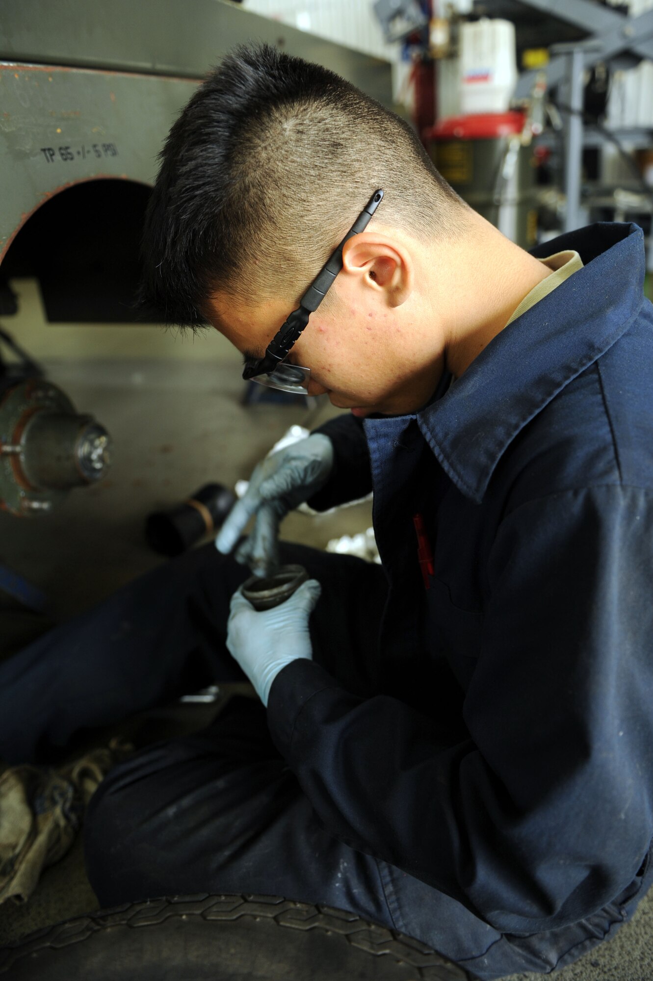 SPANGDAHLEM AIR BASE, Germany – Airman 1st Class Ernest Chim, 52nd Equipment Maintenance Squadron aerospace ground equipment apprentice, greases a dust cap on a diesel generator to prevent condensation from forming during a wheel bearing inspection at the AGE inspection and repair shop in Bldg. 185 here. The AGE flight inspects these generators every two years to ensure they operate properly, and condensation is prevented to avoid corrosion and damage to the generator. AGE members also inspect, test and operate ground support equipment to support Spangdahlem AB’s aircraft operations. (U.S. Air Force photo by Senior Airman Christopher Toon/Released)