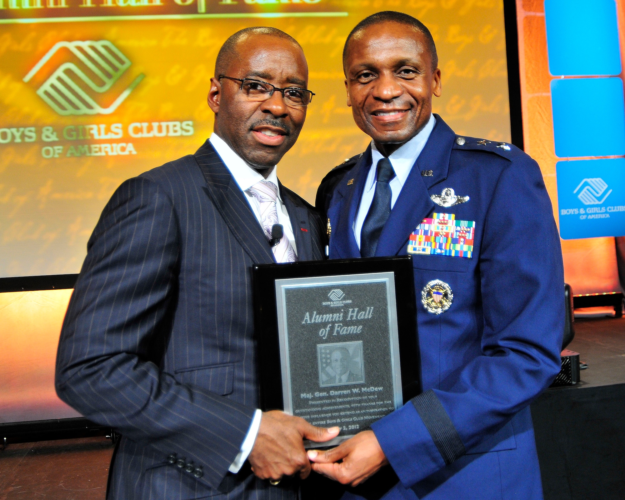 Air Force District of Washington Commander Maj. Gen. Darren McDew, a longtime supporter of the Boys and Girls Club of America, receives a plaque from Courtney B. Vance, actor, former alumni and host of the BGCA national ceremony May 2 in San Diego, Calif.  The plaque represents McDew’s induction into the BGCA Alumni Hall of Fame. McDew attended the Hampton Boys Club for five years while his father was stationed at Langley Air Force Base, Va. “I think The Boys Club gave me an opportunity to figure out who I was. I was a shy kid who read books all the time. I didn’t know much about sports and I wasn’t very good at them,” McDew said. “The Boys Club gave me role models and an opportunity to figure out I could be part of a team. The club helped me see who I could become later in life.” (U.S. Navy photo by Mass Communication Specialist 3rd Class Charlotte C. Oliver) 