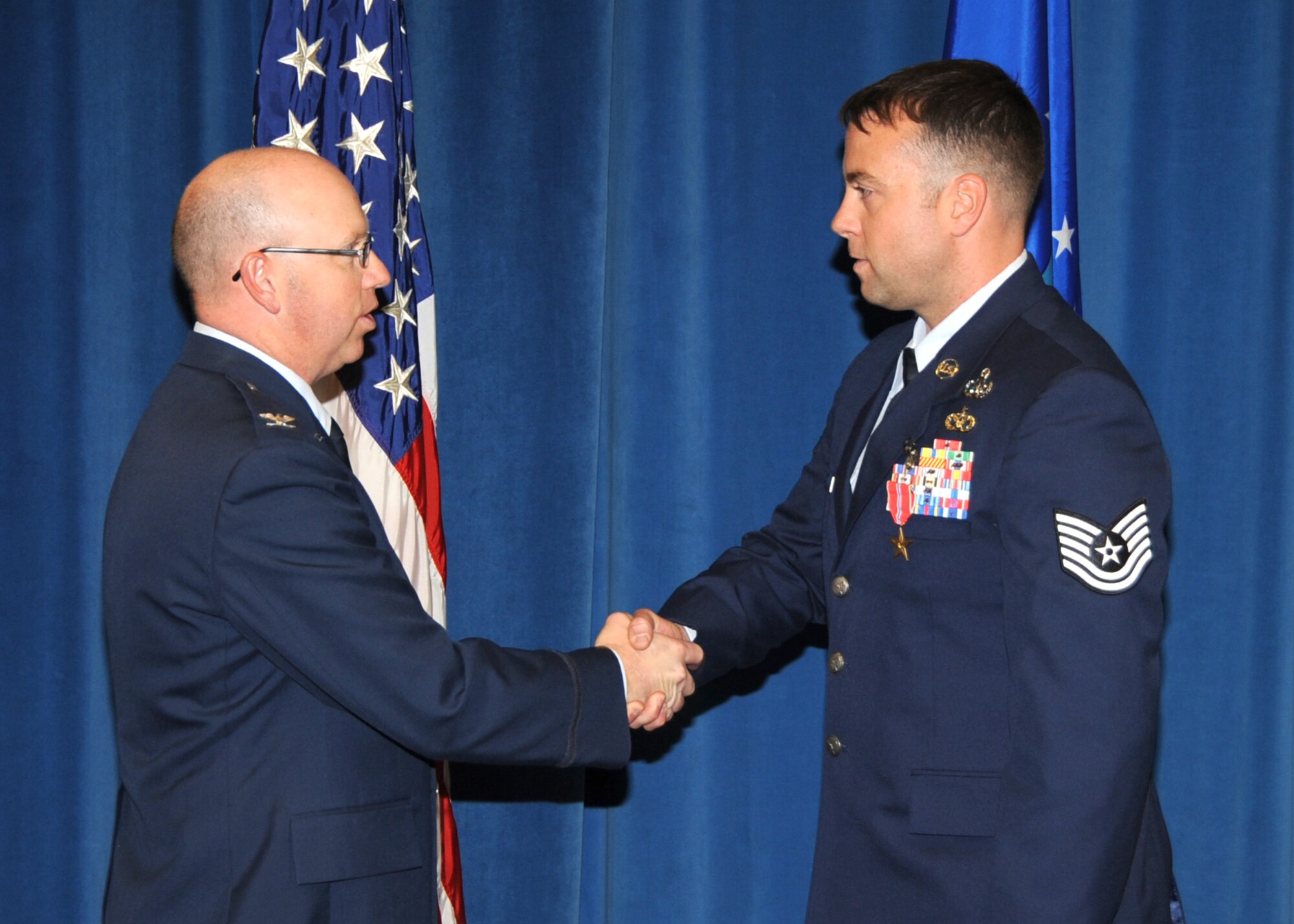 KIRTLAND AFB, N.M. -- Col. Donald Conley, 377th Mission Support Group commander, left, congratulates Tech. Sgt. Joshua Rickert, 377th Explosive Ordnance Disposal Branch, after presenting him with a Bronze Star Medal in a ceremony Wednesday at Kirtland Air Force Base. (Photo by Dennis Carlson)