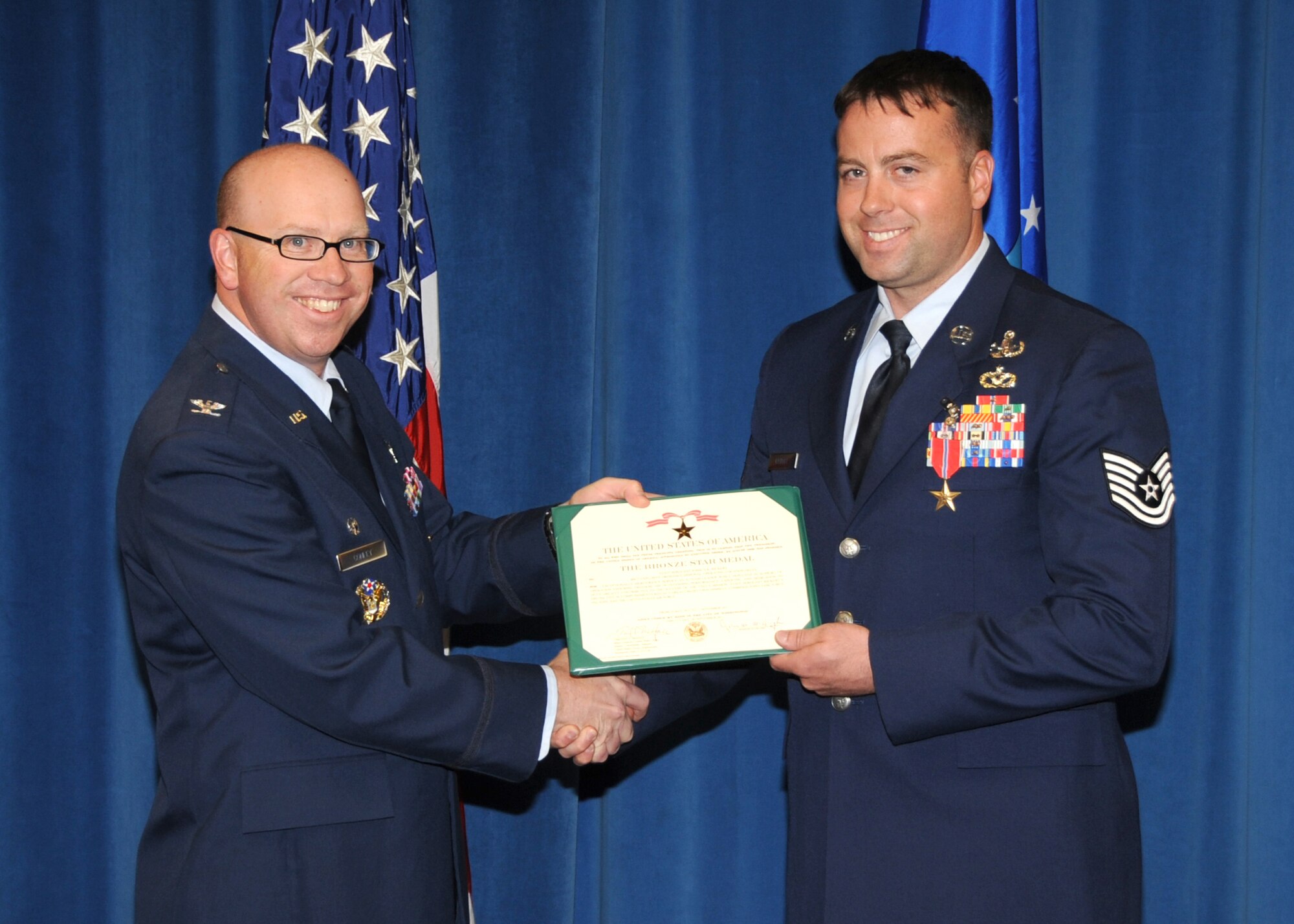 KIRTLAND AFB, N.M. -- Col. Donald Conley, 377th Mission Support Group commander, left, congratulates Tech. Sgt. Joshua Rickert, 377th Explosive Ordnance Disposal Branch, after presenting him with a Bronze Star Medal in a ceremony Wednesday at Kirtland Air Force Base. (Photo by Dennis Carlson)