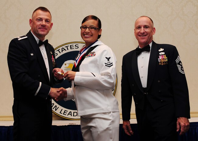 Col. Richard McComb, Joint Base Charleston commander,  and Chief Master Sgt. Earl Hannon, JB Charleston command chief, present a diploma to Petty Officer 2nd Class Crystal Medina, 628th Communication Squadron, during the Airman Leadership School Class graduation May 4 at JB Charleston - Air Base. (U.S. Air Force photo/Staff Sgt. Katie Gieratz)  