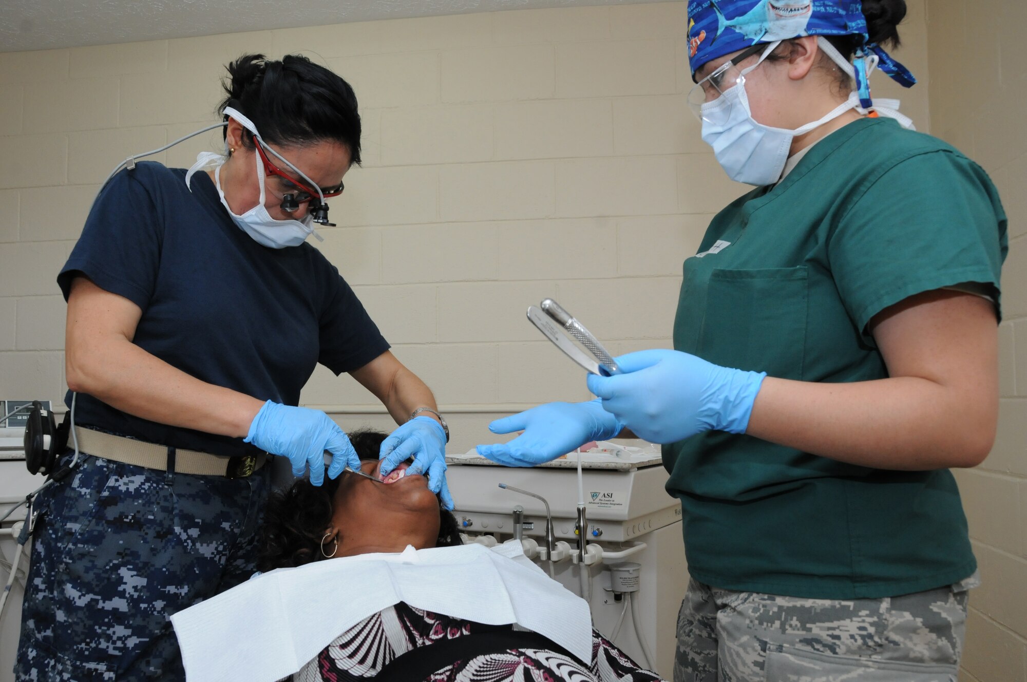 Cmdr. Carmen Bios, Navy Operational Health Support Virginia, Delta Detachment, and Airman 1st Class Jacquiline hullett, 56th Dental Clinic, Luke Air Force Base, provide a dental extraction for a patient at a Selma medical clinic in Selma, Ala. on May 1, 2012 as part of innovative readiness training mission Alabama Care. IRT Alabama Care 2012 is an Air National Guard led, multiservice mission comprised of active, reserve, and National Guard members from Army, Navy and Air Force components providing service members with readiness training while providing Alabama residents with free health services such as dental, optometry and medical screenings from May 1-10, 2012 in the medically underserved and economically depressed communities of Selma, Demopolis and Hayneville, Ala.