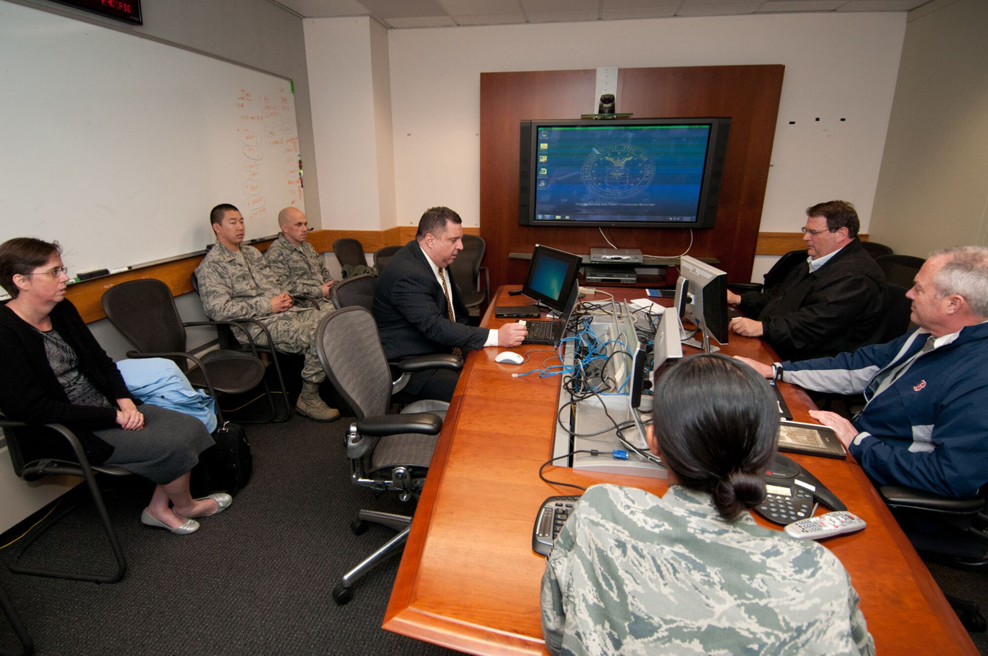 HANSCOM AIR FORCE BASE, Mass. - Ronnie Carter (center), Cyber Division chief, conducts a recall alert to telecommuting employees as part of the Ardent Sentry exercises held on May 3. Also as part of the exercise, the HNI front office group staff evacuated to an alternate location and exercised logging in to the network. (Photo by Rick Berry)