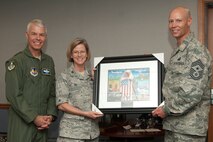 HANSCOM AIR FORCE BASE, Mass. – Col. Stacy L. Yike, 66th Air Base Group commander, presents Chief Master Sgt. Kevin Call (right), Electronic Systems Center command chief, with a “Spirit of Hanscom” print during a farewell barbecue for the chief and Lt. Gen. CR Davis, ESC commander, May 4. With the upcoming inactivation of ESC, both Davis and Call will be moving to different assignments. (U.S. Air Force photo by Walter Santos)