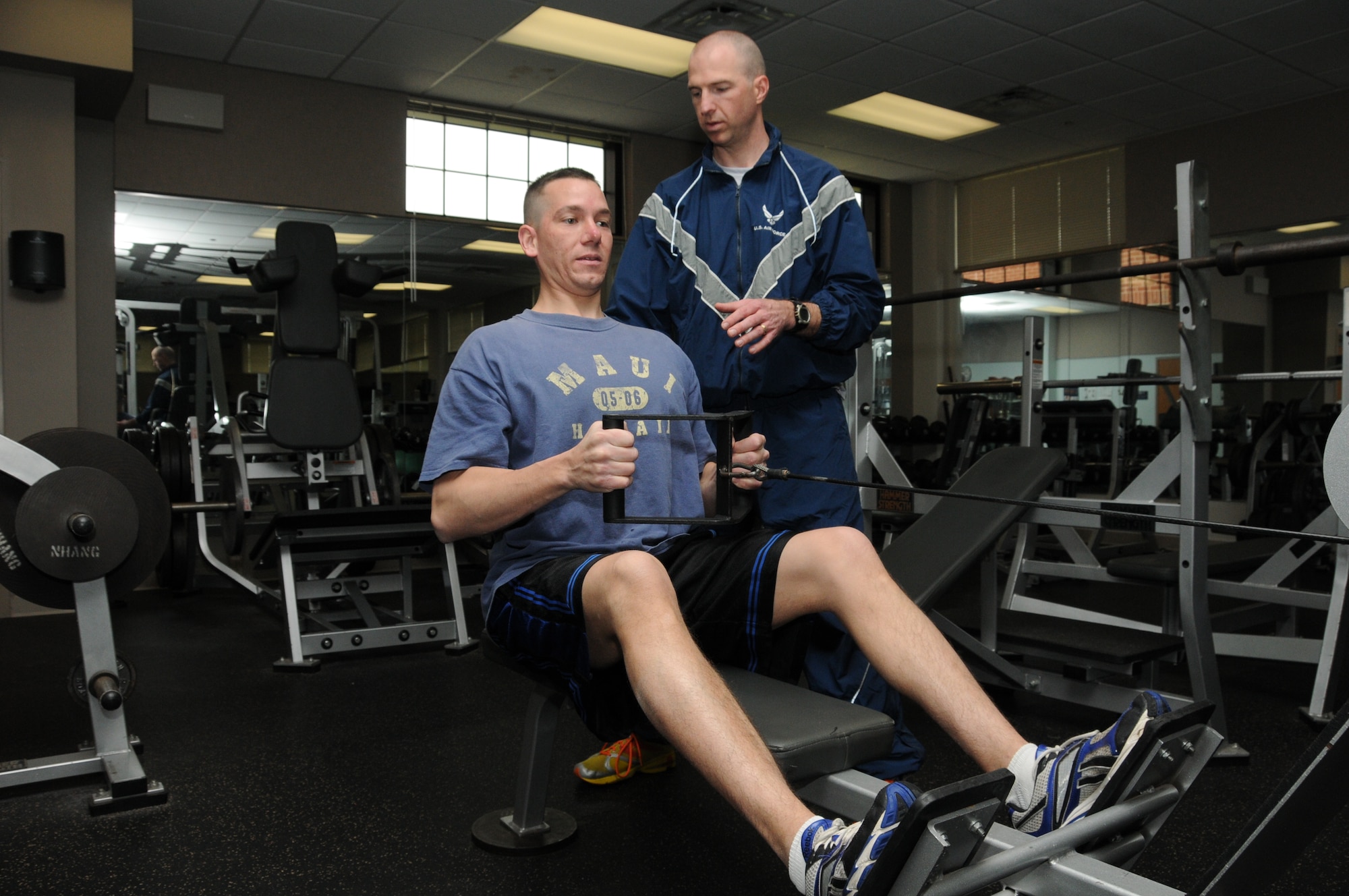 PEASE AIR NATIONAL GUARD BASE, N.H -- Tech. Sgt. Rob Rojek, 157th Force Support Squadron, assists Master Sgt. Jeffrey Vermette, Judge Advocate paralegal, with form in the weight room in Building 100 May 6. Rojek, a wellness and sports director for the Concord YMCA, worked with directors to establish a military membership program. (National Guard photo by Staff Sgt. Curtis J. Lenz/RELEASED)
