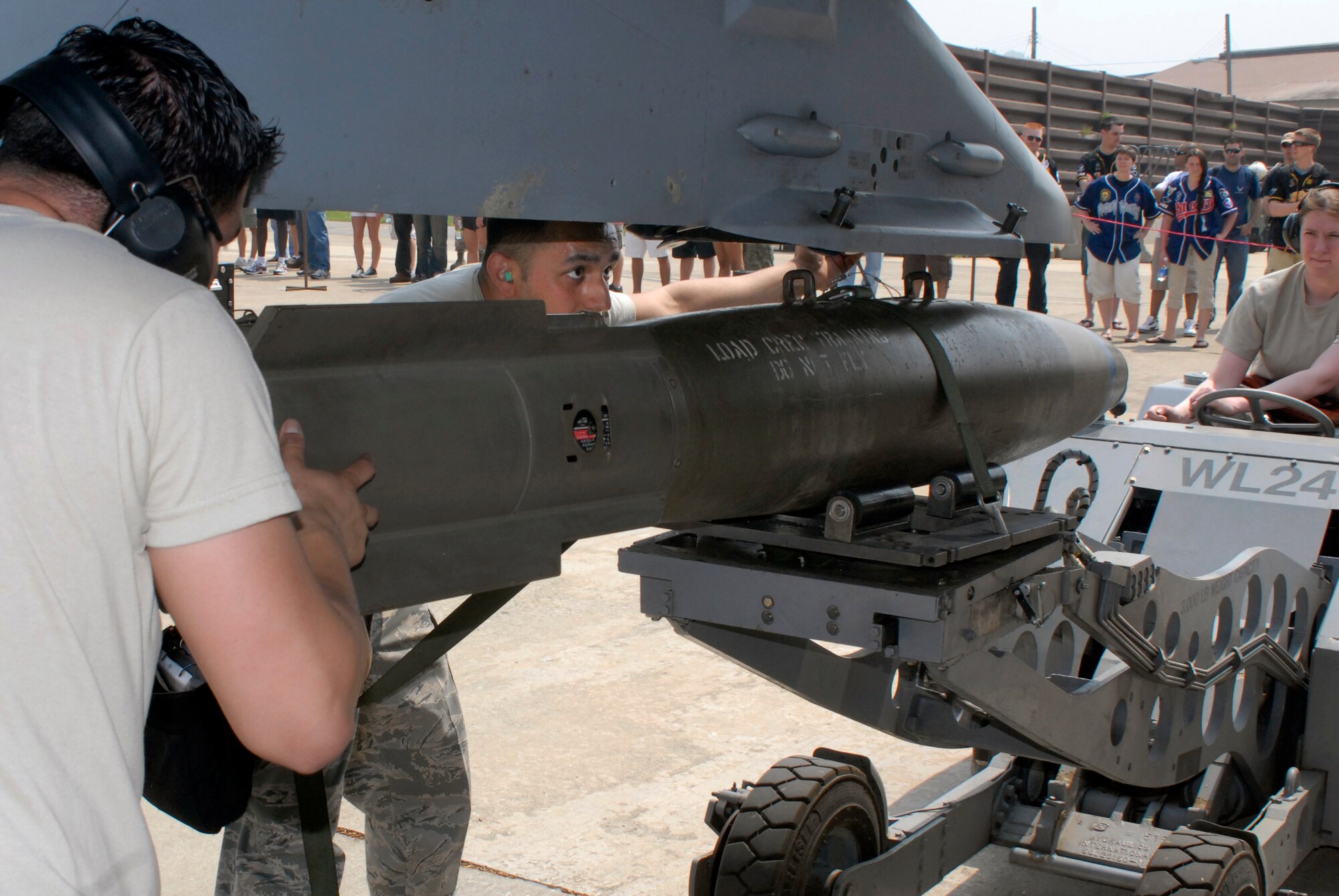 (From left to right) Airman 1st Class Enrique Melgarejo, Staff Sgt. Tim Ashdown, and Senior Airman Kimberly Johnson, 80th Aircraft Maintenance Unit weapons loaders, load a Mk-82 500-pound bomb on an F-16 during a weapon loading competition at Osan Air Base, Republic of Korea, May 5, 2012. (U.S. Air Force photo/Tech. Sgt. Eric Petosky)