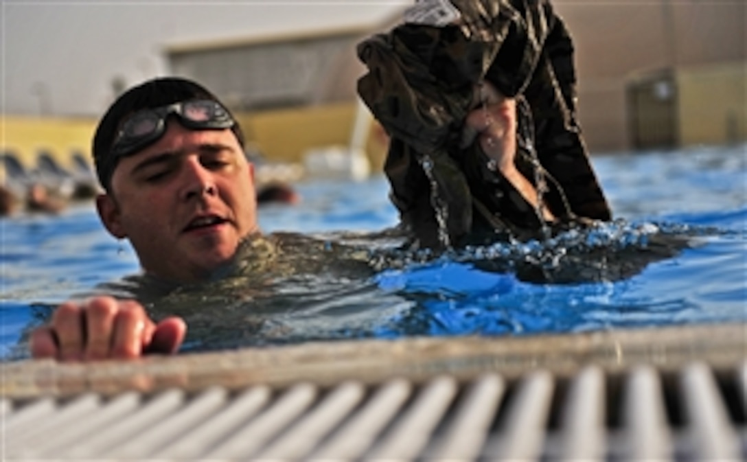 U.S. Air Force Capt. John Fuson removes his uniform top during water training in Southwest Asia, May 3, 2012. Fuson is the officer-in-charge assigned to the 380th Expeditionary Civil Engineer Squadron Explosive Ordnance Disposal. Members of the EOD flight swim as part of their training routine to stay in top physical condition.
