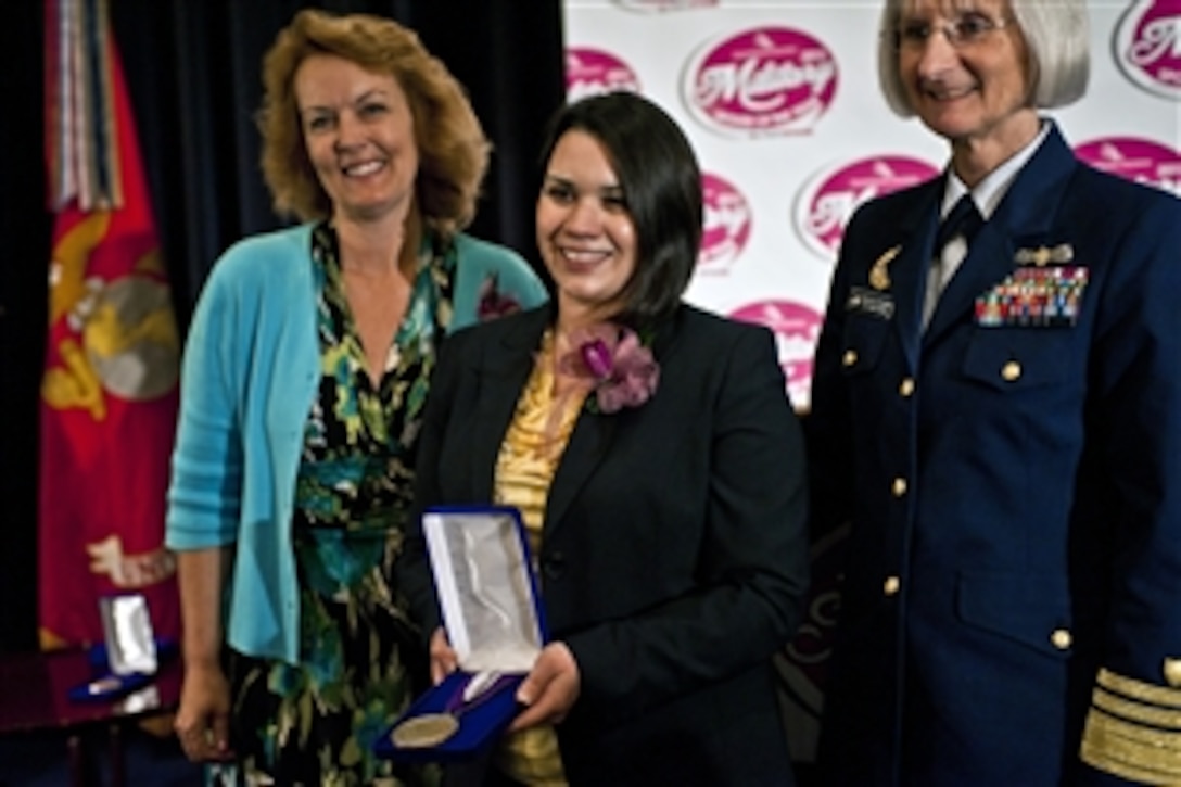 Deborah Leavitt, wife of the master chief petty officer of the Coast Guard, right, and Vice Adm. Sally Brice-O'Hara, vice commandant of the Coast Guard, present Jennifer Bassett, center, with a medal recognizing her as the 2012 Coast Guard Spouse of the Year during the 2012 Military Spouse of the Year ceremony at Marine Barracks Washington, D.C., May 10, 2012. Bassett is the wife of Coast Guard Chief Petty Officer Josh Bassett.