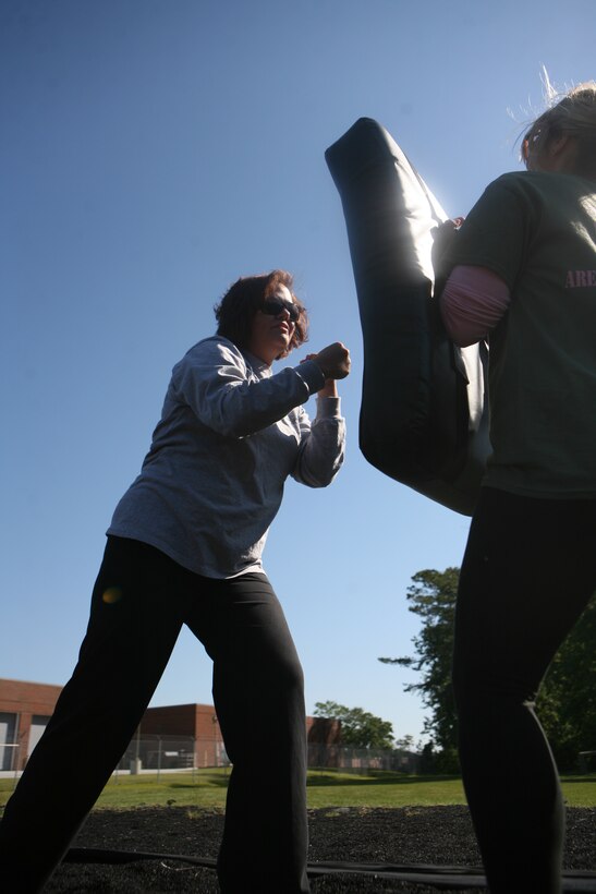 The wife of Cpl. Phillip Berger, a rifleman with Headquarters Company, 2nd Marine Regiment, 2nd Marine Division, strikes a pad during Marine Corps Martial Arts Program training May 11.  The training was part of a Jayne Wayne Day held by the regiment so the spouses of the units Marines can better understand what is routinely required of their husbands. (Official U.S. Marine Corps photo by Cpl. Clayton VonDerAhe)