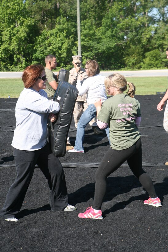 The wives of Marines serving in Headquarters Company, 2nd Marine Regiment, 2nd Marine Division, learn moves with the Marine Corps Martial Arts Program as part of a Jayne Wayne Day May 11.  The event was held to enlighten the Marines spouses to the Marine Corps lifestyle and give them insight into their husbands’ daily lives. (Official U.S. Marine Corps photo by Cpl. Clayton VonDerAhe)