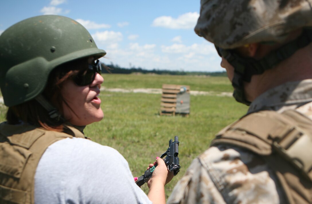 Corporal Phillip Berger (right), a rifleman with Headquarters Company, 2nd Marine Regiment, 2nd Marine Division, talks to his wife after she finished the live-fire portion of the unit’s Jane Wayne Day May 11.  Mrs. Berger shot both balloons from the target under her husband’s supervision. (Official U.S. Marine Corps photo by Cpl. Clayton VonDerAhe)
