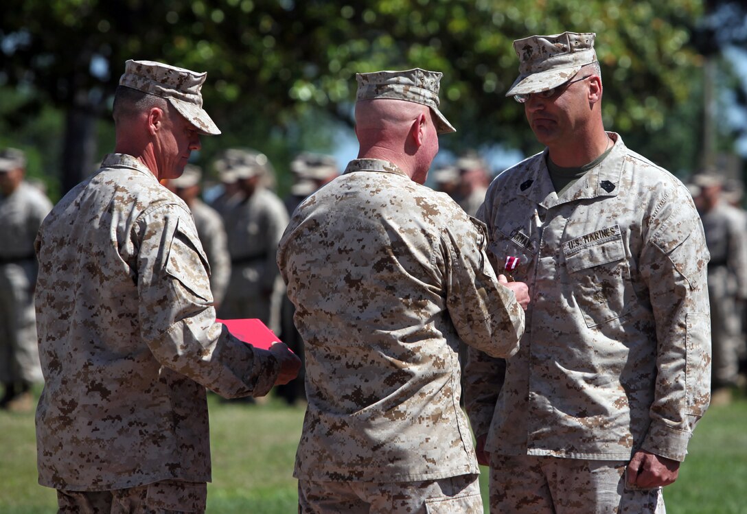 Major Gen. W. Lee Miller Jr. (center), the assistant division commander of 2nd Marine Division, presents Sgt. Maj. John C. Carman (right) of Toledo, Ohio, the Meritorious Service Medal – the thid of Carman’s 28-year career – during Carman’s retirement ceremony May 11.  Carman recently served as the sergeant major of 2nd Marine Division’s Force Generation Element while the headquarters element was deployed to Afghanistan.  (Official U.S. Marine Corps photo by Cpl. Tommy Bellegarde)