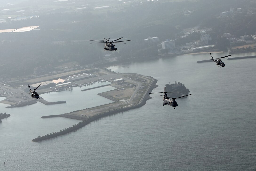 A division of helicopters from Marine Medium Helicopter Squadron 265 (REIN), 31st Marine Expeditionary Unit, featuring a CH-46E Sea Knight, CH-53E Super Stallion, a UH-1N Huey, and a AH-1W Super Cobra, fly in a diamond formation along the coast of Okinawa, May 11. The flight marks the final time these helicopters will fly as the Air Combat Element of the 31st MEU.