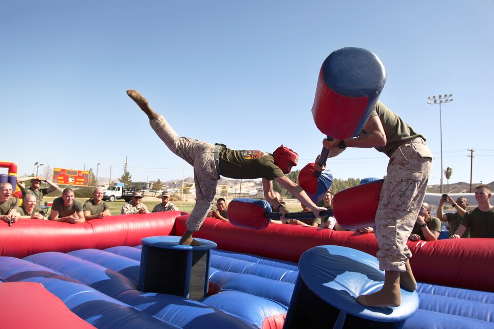 Lance Cpl. Kevin Baughman (left), motor vehicle operator, 3rd Battalion, 11th Marine Regiment, loses his balance and the match against Lance Cpl. Austin Gouveia, rifleman, 2/7, during a King of the Hill Jousting tournament.::r::::n::::r::::n::::r::::n::