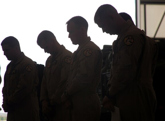 Pilots from Marine Fighter Attack Squadron 312 bow their heads as Cmdr. Gerald W. Felder, Marine Aircraft Group 31 Command Chaplain, speaks before their departure to Oceana, Va.