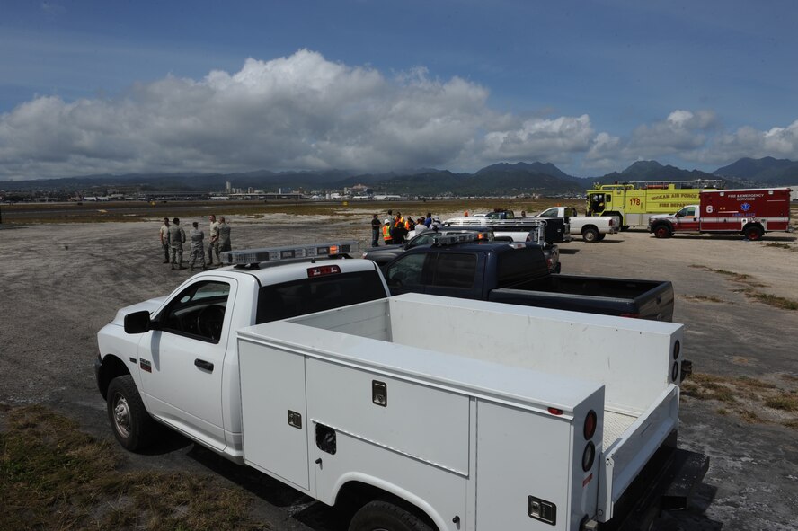 Members of the 647th Civil Engineer Squadron stand by the Honolulu International Airport flightline in preparation to test a BAK-12 aircraft arrest system May 8. The three arrest systems here are maintained by the 647th CES and Navy Facilities Engineering Command and are utilized by the deployment of an arresting hook in the rear of the aircraft as a last resort measure when pilots are unable to stop. (U.S. Air Force photo by Staff Sgt. Nathan Allen)