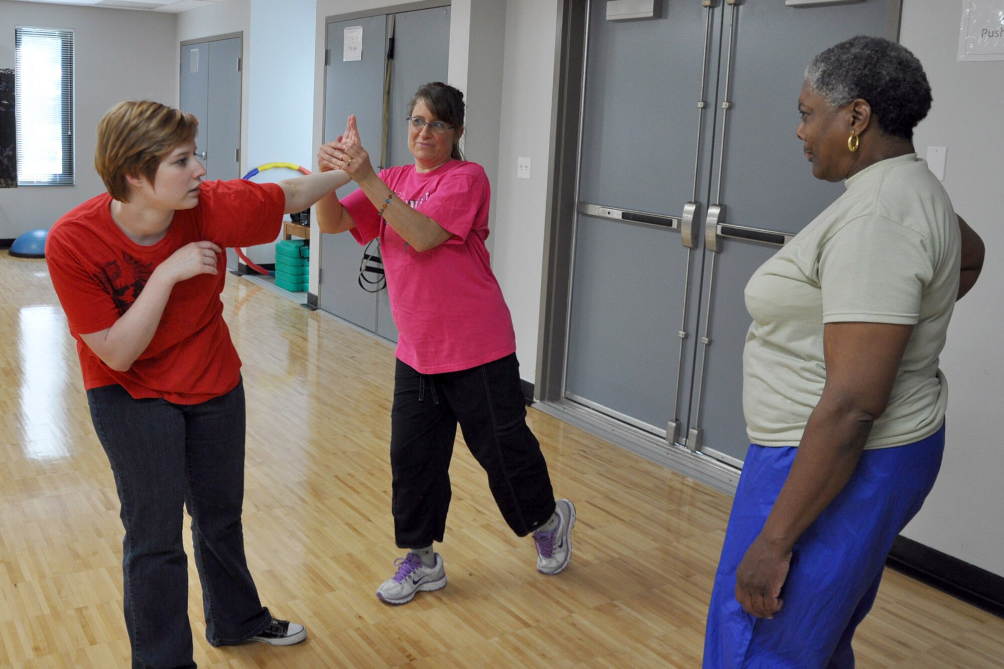 YOUNGSTOWN AIR RESERVE STATION, Ohio – Air Force Reserve Tech. Sgt. Madeline Moon (right), a customer service specialist with the 910th Force Support Squadron, watches as Deana Barko (center), the wife of a 910th Citizen Airmen, uses a self defense technique on Brielle Campos (left), a Certified Instructor with ATA Martial Arts*, based in nearby Boardman, Ohio, during a self defense course at the Fitness Center here, May 5, 2012. Sergeant Moon and Mrs. Barko are among a group of more than twelve Reservists, family members and Department of Defense employees attending the free class hosted by the 910th Community Services Flight (CSF). The activity is one of the many offered to those utilizing the facilities at YARS. For more information about 910th CSF activities, call 330-609-1334. *No federal endorsement implied. U.S. Air Force photo by Master Sgt. Bob Barko Jr.