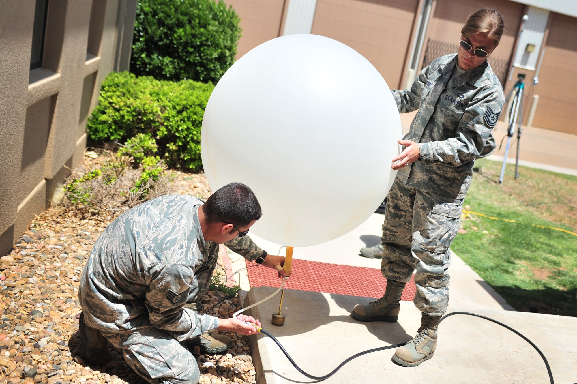 U.S. Air Force Tech. Sgt. Sara Meyer and Staff Sgt. Phillip Tori, 27th Special Operations Support Squadron weather forecasters, finalize preparations on a weather balloon before launch near the flightline at Cannon Air Force Base, N.M., May 9, 2012. Troops with the weather flight at Cannon deal largely with resource protection and are able to track any weather systems that directly impact the base or personnel. (U.S. Air Force photo by Airman 1st Class Alexxis Pons Abascal)  