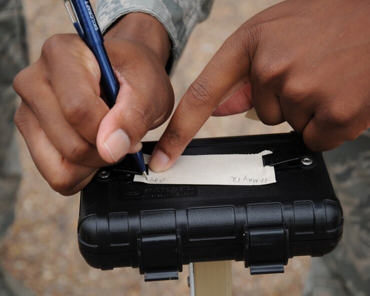 A Barksdale Airman writes the time and date on a piece of M8 chemical agent detection paper during an Ability to Survive and Operate exercise on Barksdale Air Force Base, La., May 11. The paper is used to detect nerve and blister agents in the air. (U.S. Air Force photo/Senior Airman Sean Martin)(RELEASED)