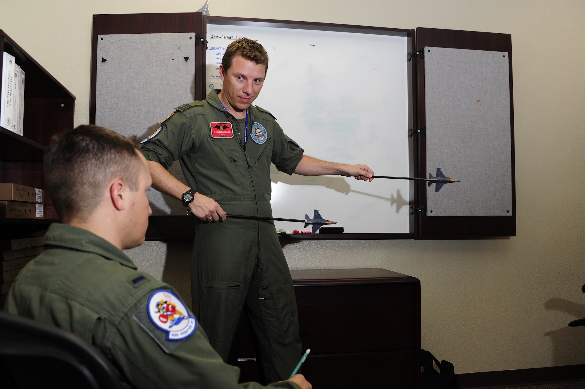 Royal Danish air force Maj. Jimmy Kjelsgaard, 62nd Fighter Squadron exchange officer and instructor pilot, reviews flight sight pictures using model F-16 Fighting Falcons with 1st Lt. Derek Kirkwood, 62nd FS student pilot, at Luke Air Force Base April 25. Instructors use the models to help demonstrate the principles explained in classrooms and flight briefings.  (U.S. Air Force photo by Staff Sgt. Jason Colbert)