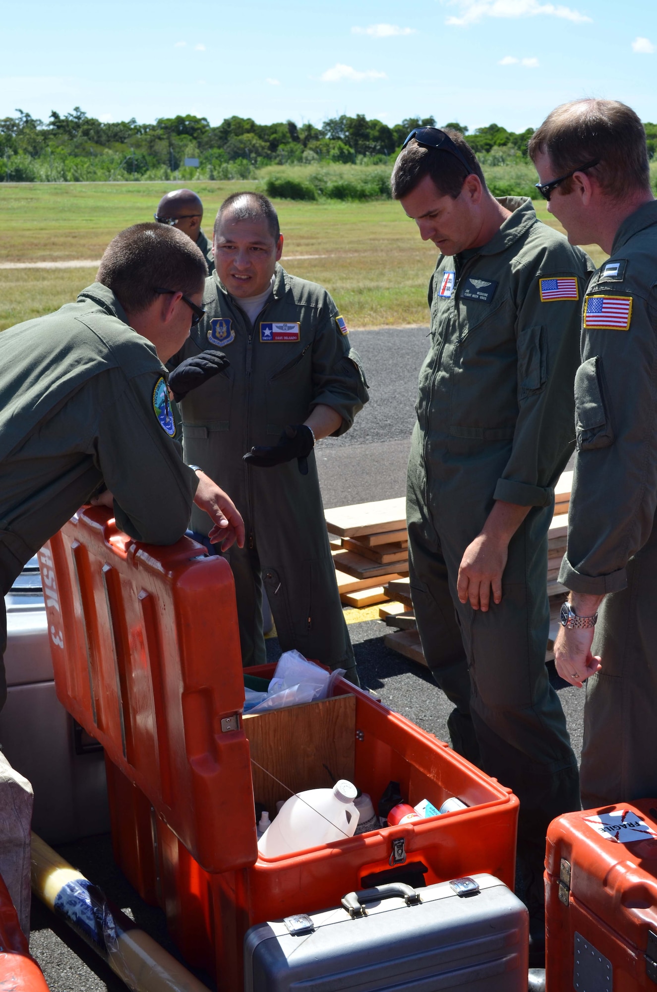 Senior Master Sgt. David Delgado (center), 433rd Airlift Control Flight Contingency Respone Team chief, explains to U.S. Coast Guard air crew members Petty Officers First Class Chris Wood, Joe McQuire and Lt. Rob O'Donnell the size of a container to transport a certain hazardous substance during a joint inspection for cargo to transport onboard a 433rd Airlift Wing Galaxy C-5A in Cairns, Austraila on May 6, 2012. (U.S. Air Force Photo/Maj. Tim Wade)