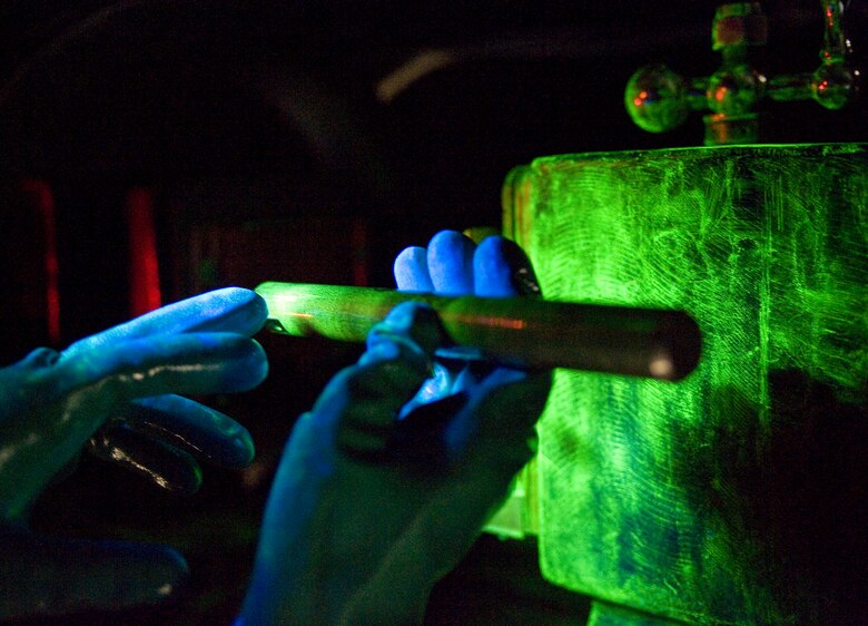 Senior Airman Paul Nessle, 2nd Maintenance Squadron non-destructive inspector, checks for cracks on an aircraft part during a fluorescent magnetic particle test on Barksdale Air Force Base, La., May 9. When applied to a magnetized part, the solution accumulates in small cracks, making them visible under a black light. (U.S. Air Force photo/Staff Sgt. Chad Warren)(RELEASED)