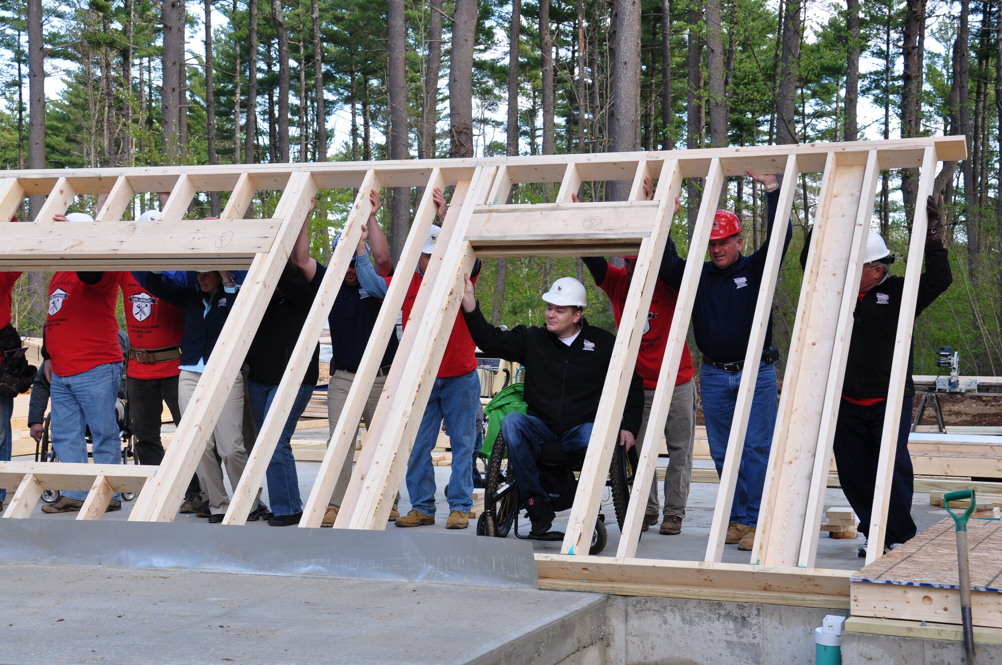 Wounded Marine, Sgt. Joshua Bouchard helps lift the first wall on his wheelchair-accessible home. (U.S. Air Force photo/Lt. Col. James Bishop)