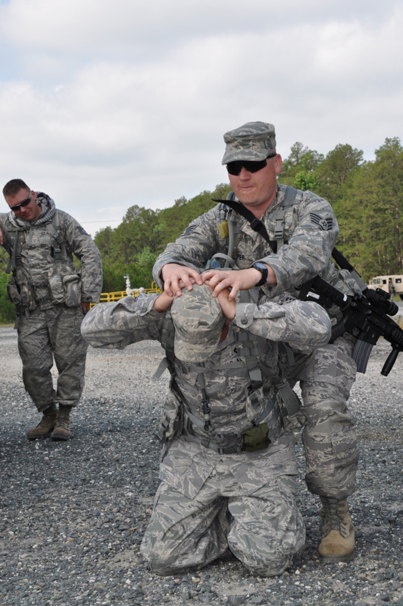 Staff Sgt. James Cosper, 307th Security Forces Squadron, simulates arresting Staff Sgt. Johnathan Maupin, 307th SFS, while Tech. Sgt. Jason Fruge, 307th SFS, looks on as part of the Bivouac held May 5-6, 2012, at the Warfare Training Center on Barksdale Air Force Base, La.  Exercises included land navigation, improvised explosive device (IED) detection and hostile vehicle stops and searches. (U.S. Air Force photo/Master Sgt. Mary Hinson)