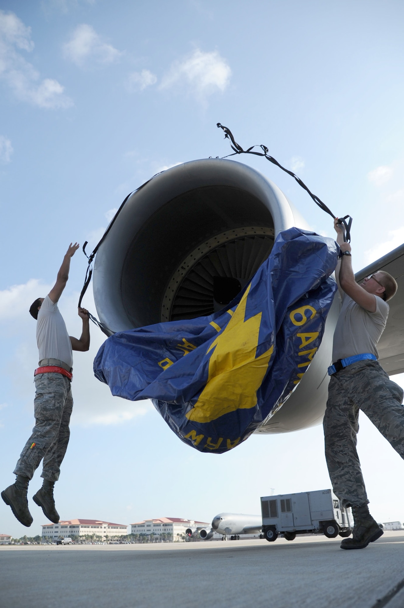 MACDILL AIR FORCE BASE, Fla. -- Making a leap of faith around jet engines is something maintainers do well.  Here, Airmen First Class Ryan Baez and Bodine Todd, both crew chiefs with the 6th Air Mobility Wing, secure a cover over a KC-135 Stratotanker’s jet engine prior to a static display of the aircraft.  (Official U.S. Air Force photo/Staff Sgt. Shawn Rhodes) 