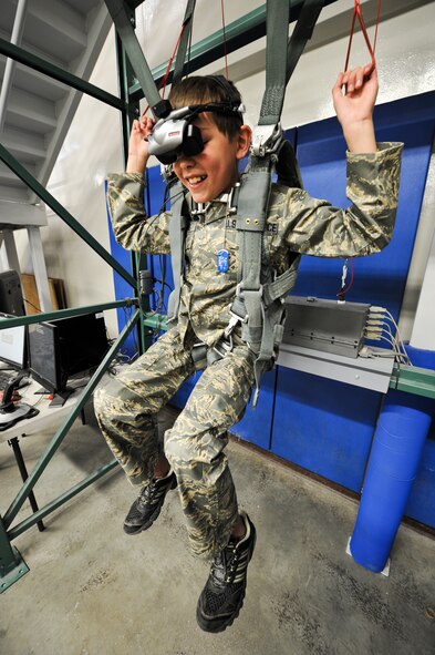 Samuel Burke, a 10-year-old Spokane, Wash., boy fighting a cancerous tumor on his optic nerve, experiences the 336th Training Group’s hanging harness trainer during Burke’s tour of various agencies across the installation at Fairchild Air Force Base, Wash., May 4, 2012. Sam has undergone 1.5 years of chemo therapy. (U.S. Air Force photo by Senior Airman Benjamin Stratton/Released)