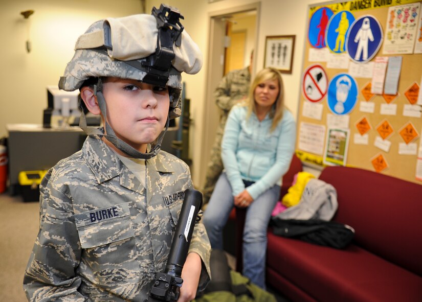 Samuel Burke, a 10-year-old Spokane, Wash., boy fighting a cancerous tumor on his optic nerve, tries on the 92nd Civil Engineer Squadron’s explosive ordinance disposal expeditionary gear during his tour of various agencies across the installation at Fairchild Air Force Base, Wash., May 4, 2012. Sam was the first community member to participate in the newly constructed program deemed, “Airman for a Day”. (U.S. Air Force photo by Senior Airman Benjamin Stratton/Released)