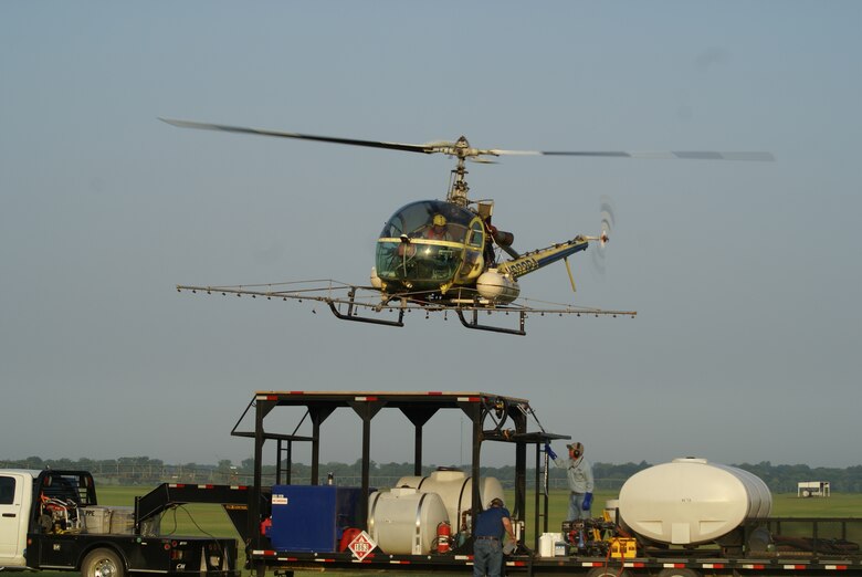 OKLAHOMA — A helicopter prepares to land on the refueling platform after spraying one of the Interior Least Tern islands along the McClellan-Kerr Arkansas River Navigation System in Oklahoma. The Corps used an EPA-approved herbicide to spray the island for the bird, which prefers barren sandbars along river systems as habitat.