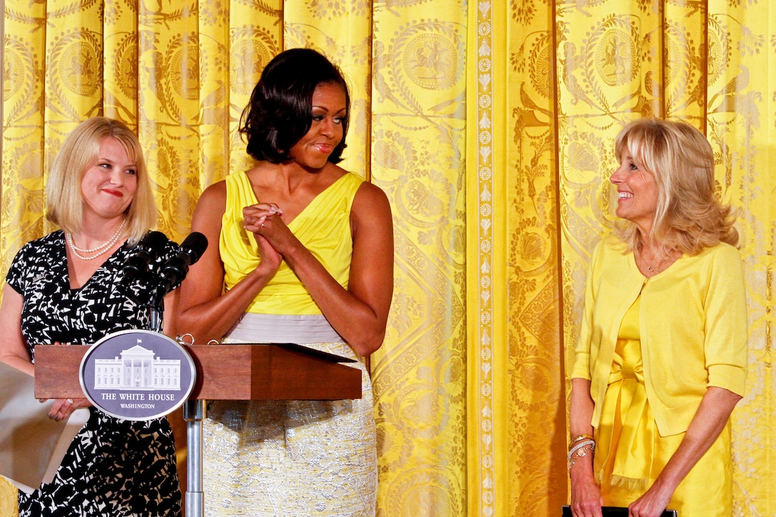 First Lady Michelle Obama leads the applause for Dr. Jill Biden, a military mom and wife of Vice President Joe Biden, as Jennifer Pilcher, a Navy spouse, looks on during a Joining Forces Mother's Day event for three generations of military families at the White House in Washington, D.C., May 10, 2012.
