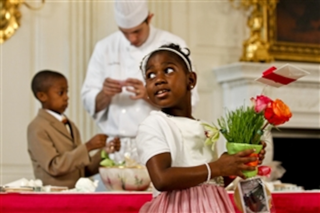 A girl holds a plant decoration she will present to her military familiy during a Joining Forces Mother's Day event hosted by First Lady Michelle Obama and Dr. Jill Biden, wife of Vice President Joe Biden, at the White House in Washington, D.C., May 10, 2012. Children of military families later joined their mothers and grandmothers for a tea in the East Room.