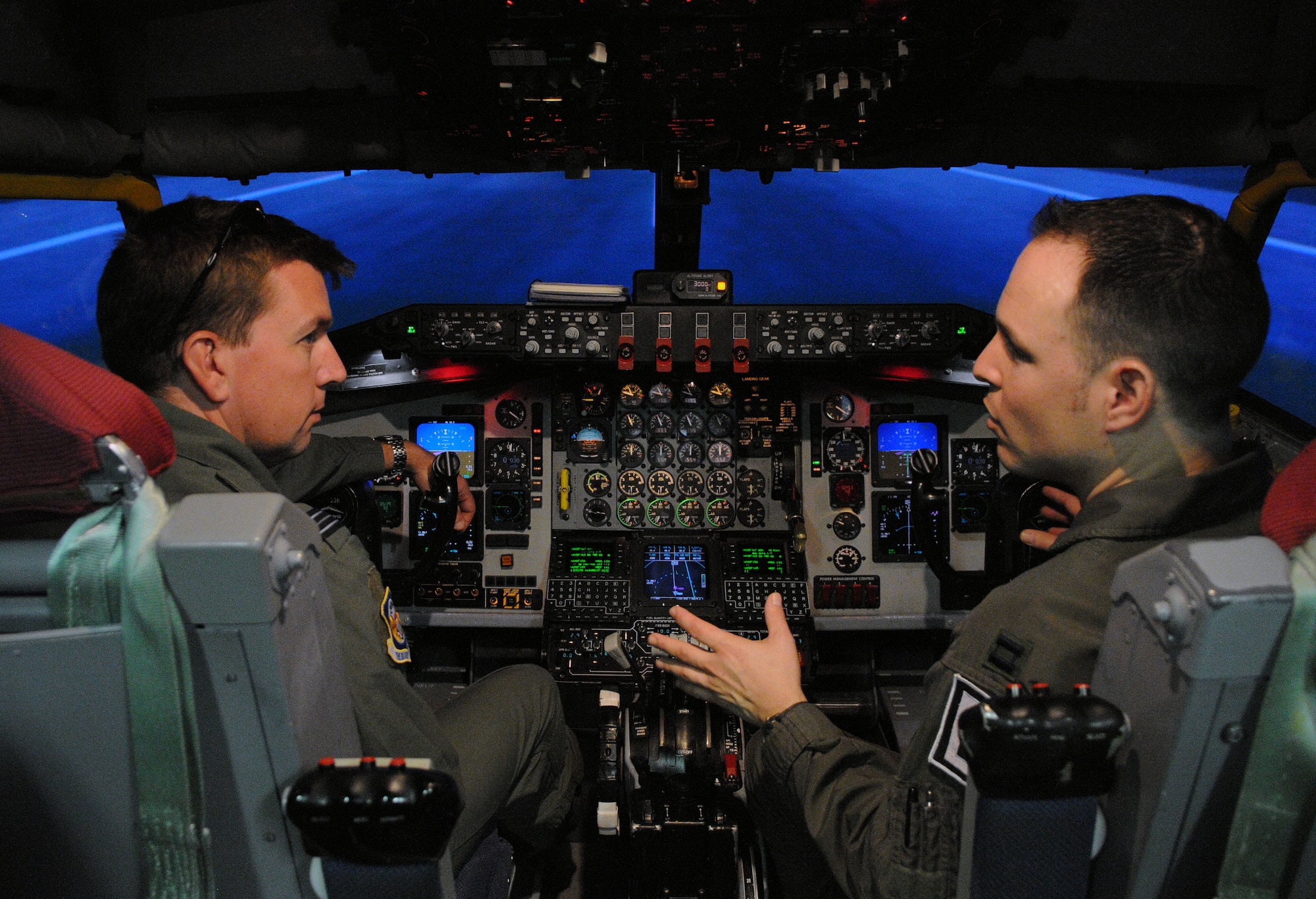 RAF MILDENHALL, England -- Capt. Aaron Marx (right), 351st Air Refueling Squadron instructor pilot, demonstrates the capabilities of a KC-135 Stratotanker in the flight simulator here May 11, 2012, to Royal Air Force Flt. Lt. Damian Massingham. Massingham was one of the attendees of the European Tanker Symposium, a multinational training event.  (U.S. Air Force photo/Senior Airman Rachel Waller)