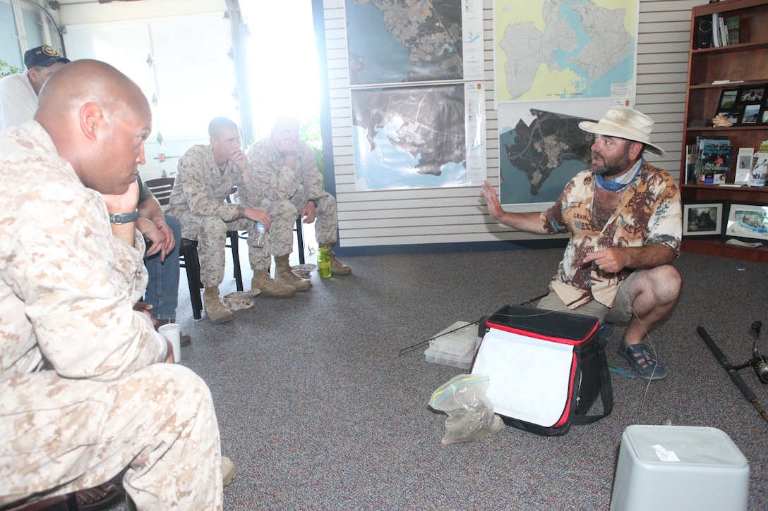 Capt. Phil Leonard holds a rod in his hand as he addresses base patrons during a shark fishing class in the Outdoor Adventures office aboard Marine Corps Base Camp Lejeune, N.C., May 2.