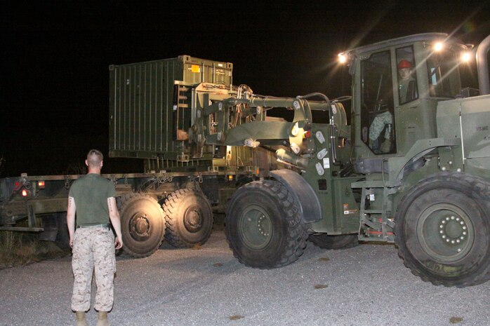 Marines with Marine Wing Support Squadron 171, Marine Aircraft Group 12, heavy equipment operators unload crates containing cots and tents during Exercise Geiger Fury 2012, May 14, 2012. The Marines worked late into the night, keeping a steady pace to construct the forward operating base.