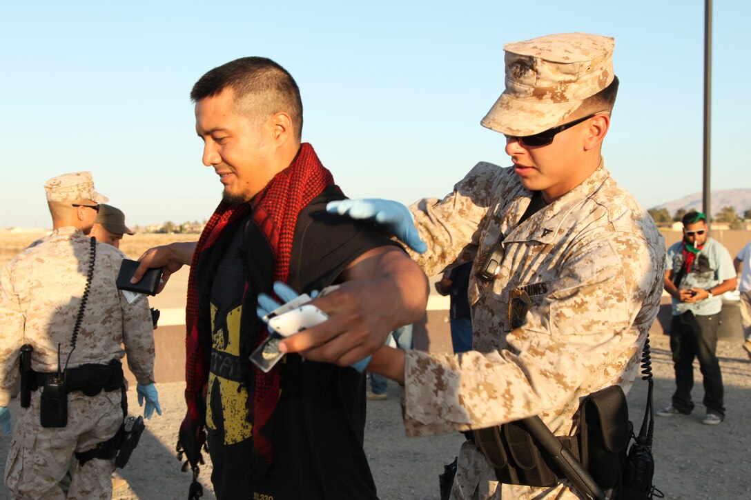 Lance Cpl. O'Donnell, military policeman, Provost Marshal's Office, pats down a new role player entering the base for the next Enhanced Mojave Viper Cycle, May 14, 2012. The MPs searches are augmented by military working dogs, who sniff out contraband like explosives and narcotics. (Official USMC photo by Sgt. Heather Golden / Released)