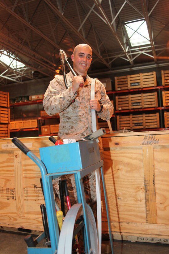 Lance Cpl. Michael R. Loucel, a warehouse clerk with Marine Air Control Squadron 2, poses with rack of tools he uses to seal boxes shut inside the Marine Air Controls Squadron 2 supply warehouse May 14.