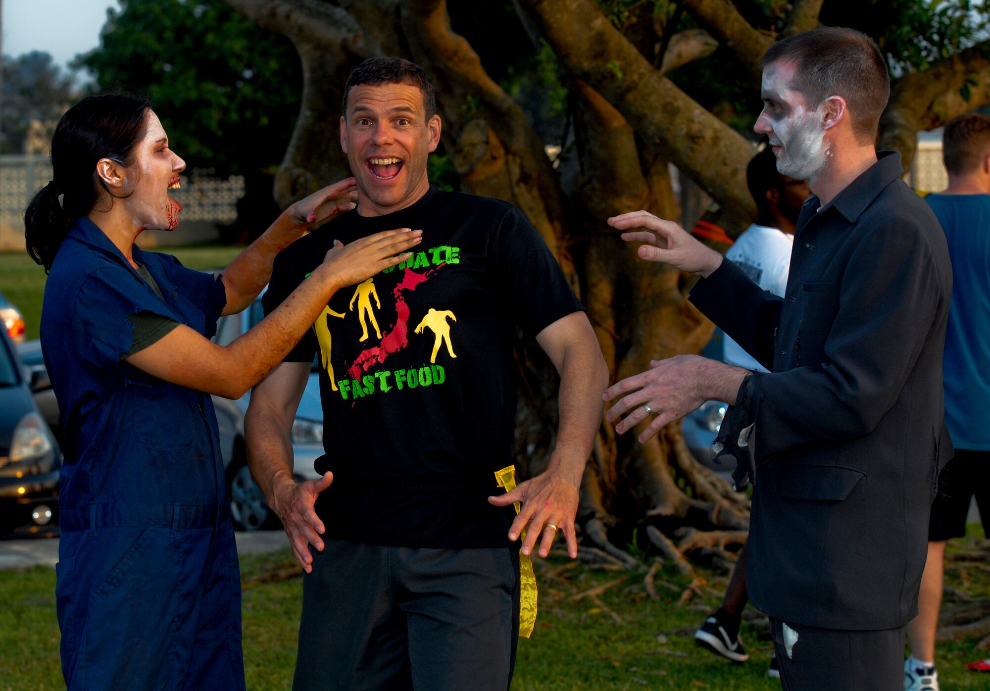 U.S. Air Force Brig. Gen. Matthew Molloy, 18th Wing commander, is attacked by two "zombies" during a Zombie 5K for That Others May Live Foundation on Kadena Air Base, Japan, May 11, 2012. Participants not only ran the three miles course but defeated different challenges while avoiding the zombies who were trying to capture their flags. The obstacle course had more than 700 runners as well as raised more than $12,000 dollars in funds for the That Others May Live Foundation. (U.S. Air Force photo/Airman 1st Class Malia Jenkins)