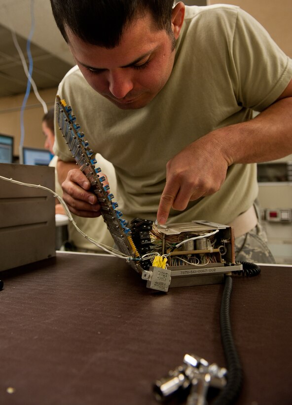Senior Airmen David Fisher, 28th Maintenance Squadron avionics technician, removes connectors from a central integrated test system data acquisition unit motherboard to replace guide pin sleeves in the digital analog video avionics shop on Ellsworth Air Force Base, S.D., May 9, 2012. The guide pin sleeves secure the unit in the B-1 bomber and also act as a ground for electric currents. (U.S. Air Force photo by Airman 1st Class Kate Thornton/Released) 