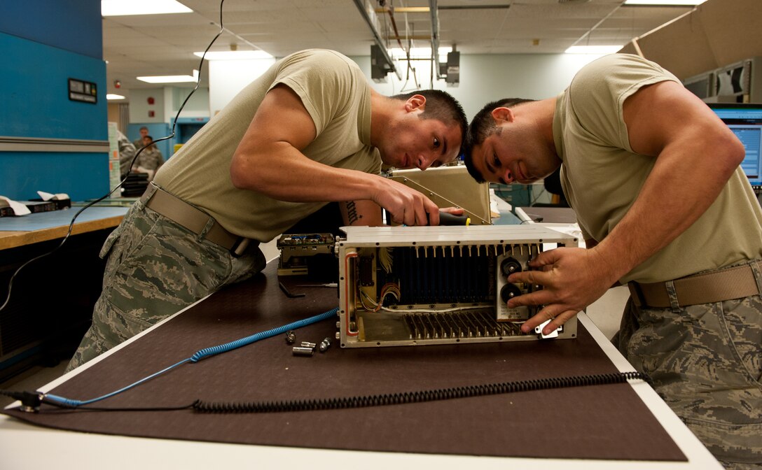 Senior Airmen Steven Rosales (left) and David Fisher, 28th Maintenance Squadron avionics technicians, remove a motherboard from a central integrated test system data acquisition unit to replace guide pin sleeves at the digital analog video avionics shop on Ellsworth Air Force Base, S.D., May 9, 2012. The unit allows the B-1 bomber avionics systems to operate correctly and is secured within the B-1 by guide pin sleeves. (U.S. Air Force photo by Airman 1st Class Kate Thornton/Released)