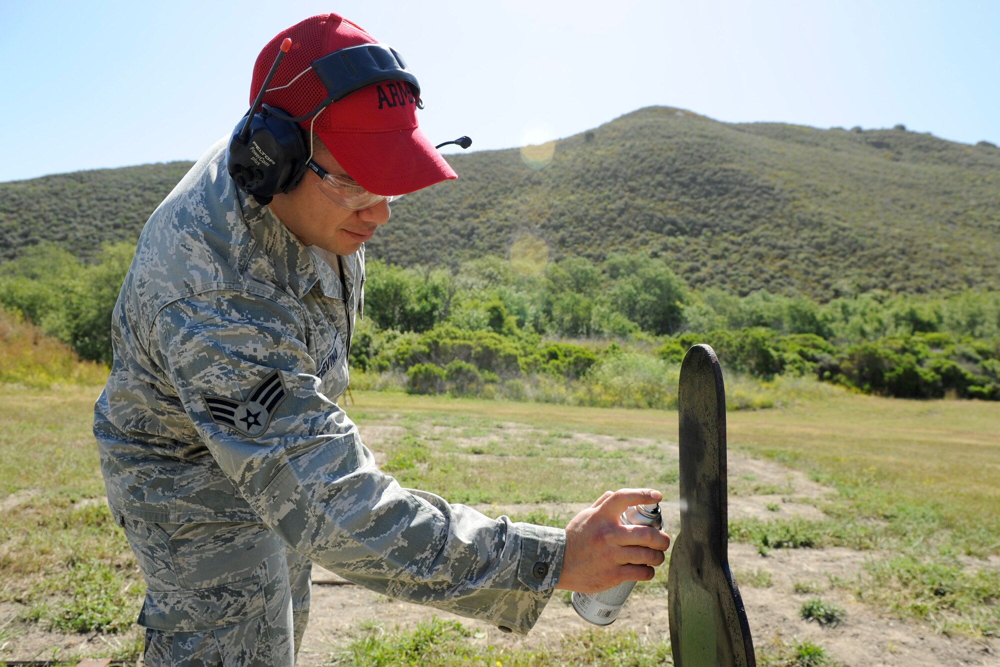 VANDENBERG AIR FORCE BASE, Calif.-- Senior Airman David Trevino, a 30th Security Forces Squadron Combat Arms Training instructor, spray-paints a target between course runs during a pistol competition at the combat arms training range here Monday, May 14, 2012. The competition was held in conjunction with National Police Week, an annual celebration that recognizes the service and sacrifice of U.S. law enforcement personnel. (U.S. Air Force photo/Staff Sgt. Levi Riendeau)
